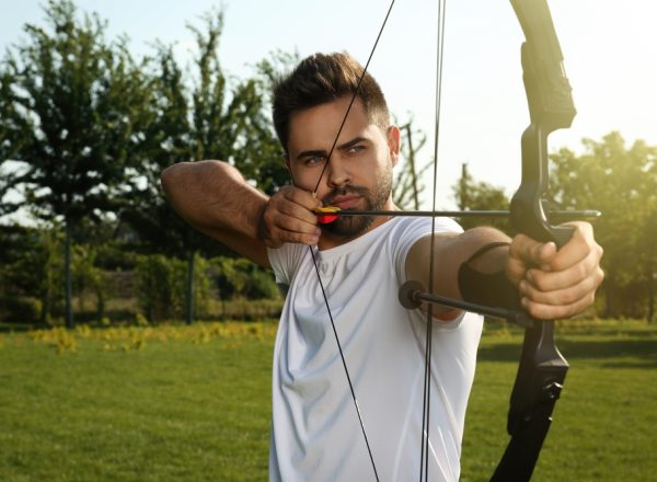 Man,With,Bow,And,Arrow,Practicing,Archery,In,Park