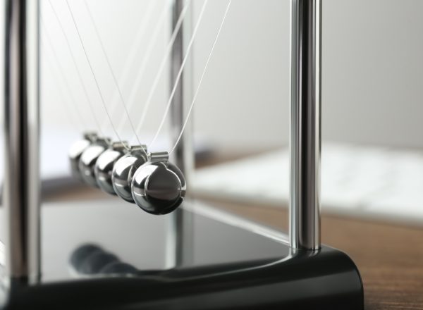 Newton's,Cradle,On,Wooden,Table,,Closeup.,Physics,Law,Of,Energy